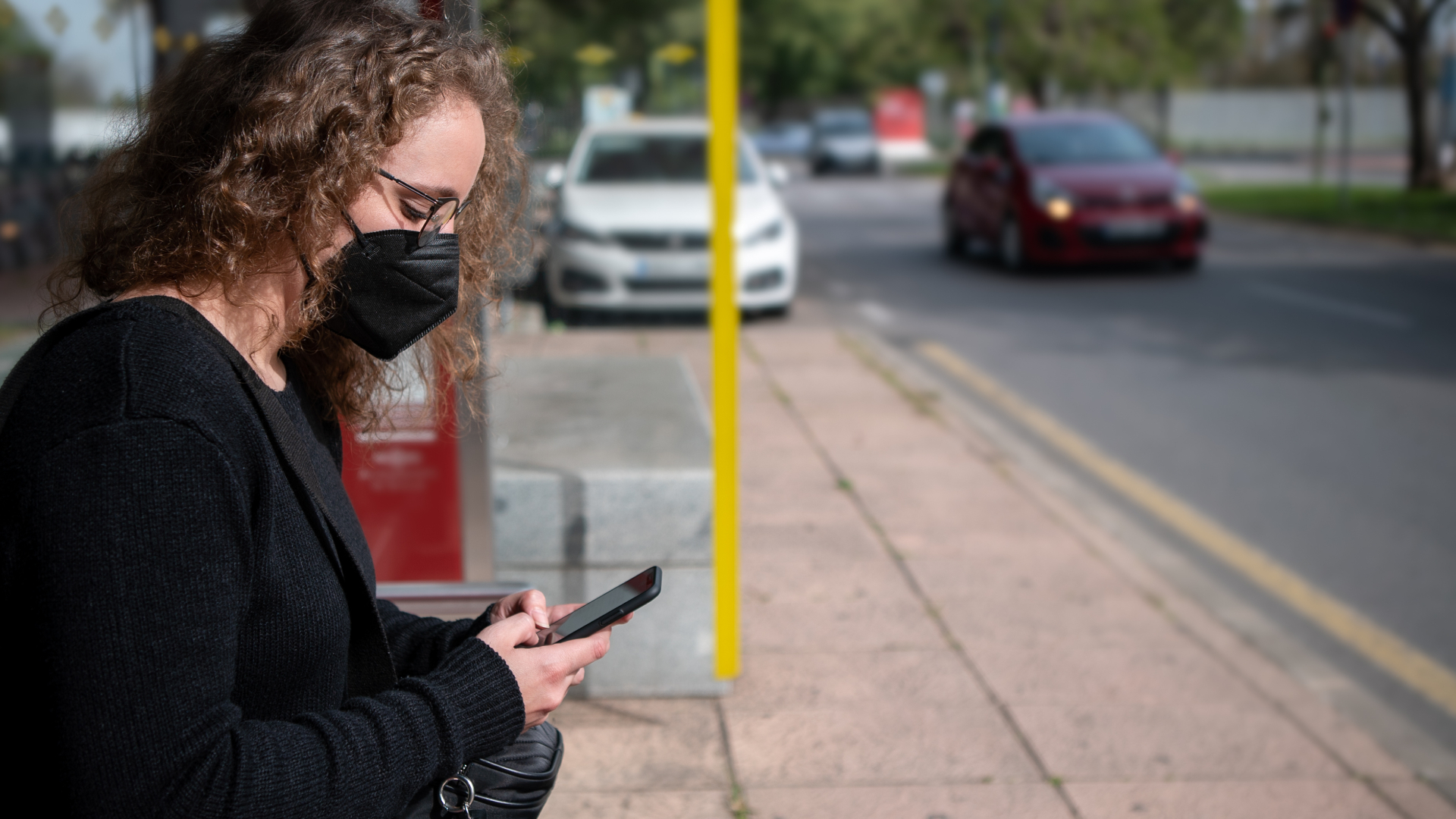 Masked woman looking at phone