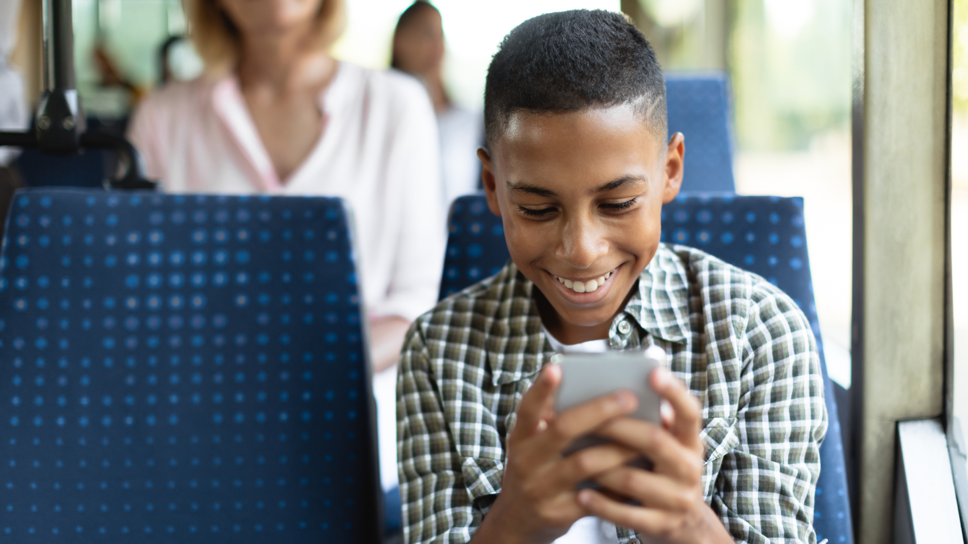 Young man on bus looking at phone