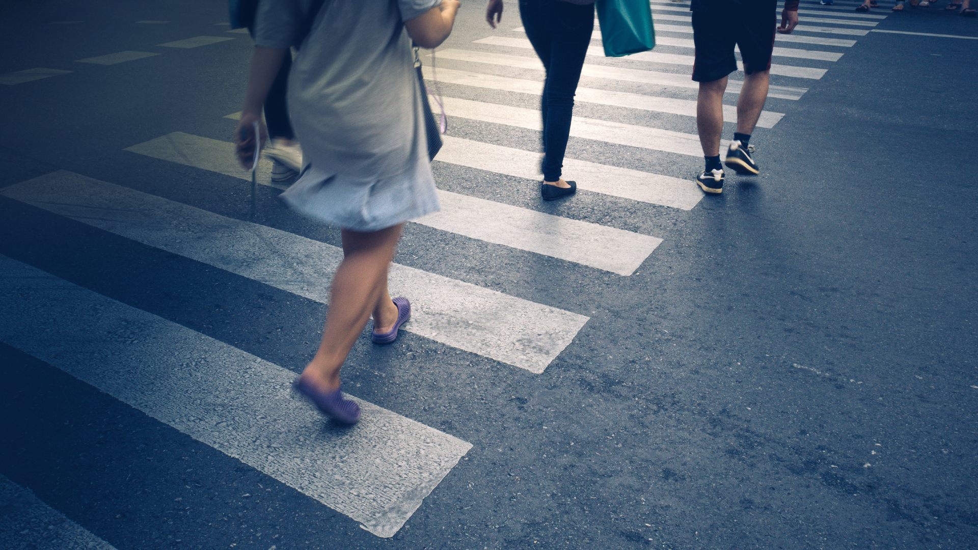 Motion of pedestrian zebra crossing or crosswalk in asia. Feet of the pedestrians crossing on city street closeup.