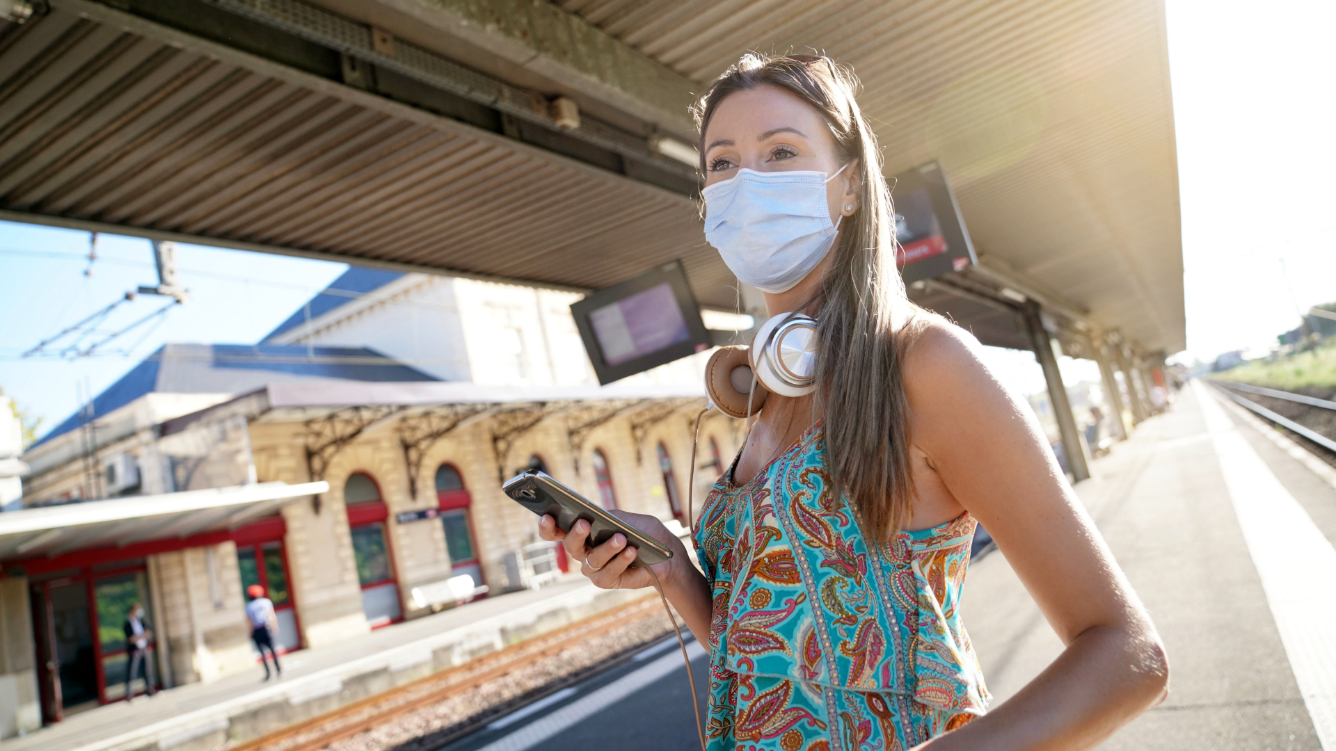 Masked woman waiting for train