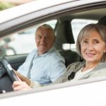 Mature couple sitting in car. Woman sitting at driver's seat.