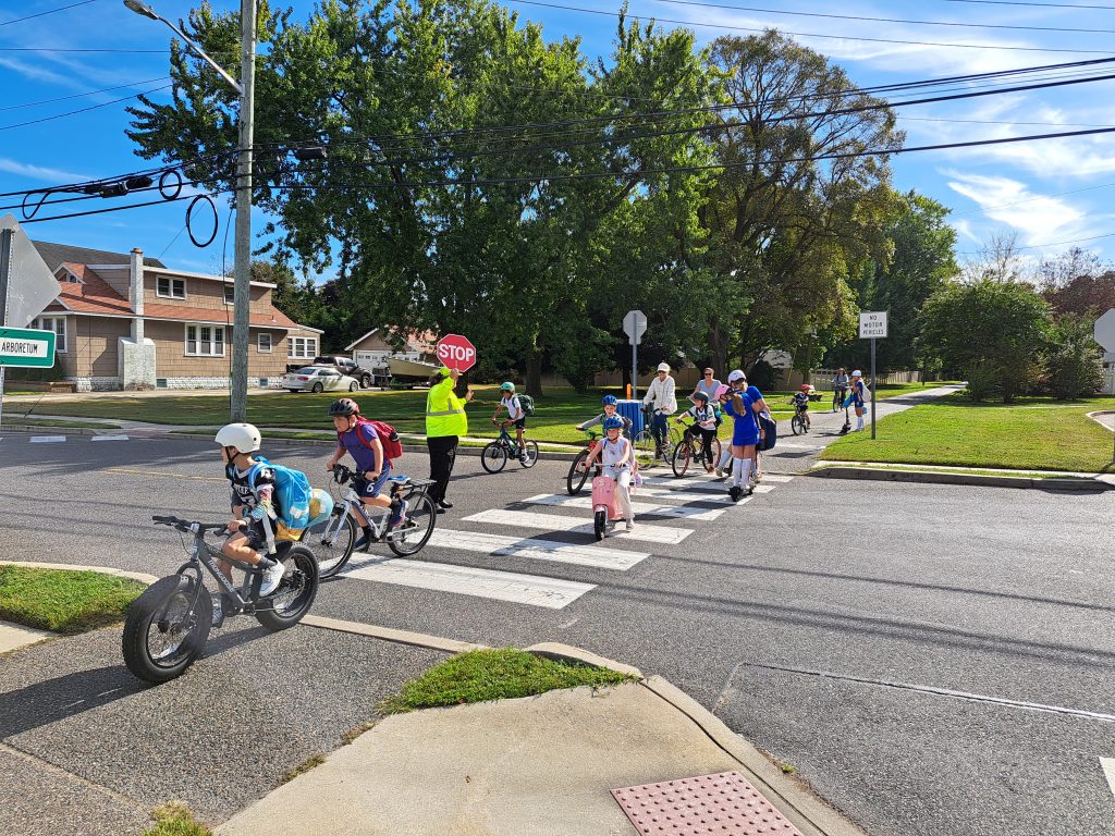 Kids biking and rolling to school at crosswalk